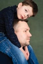 Boy sits on fatherÃ¯Â¿Â½s neck and hugs with his hands Royalty Free Stock Photo